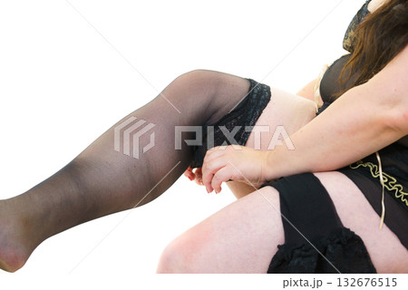 Woman plus size puts on black nylon stockings 132676515