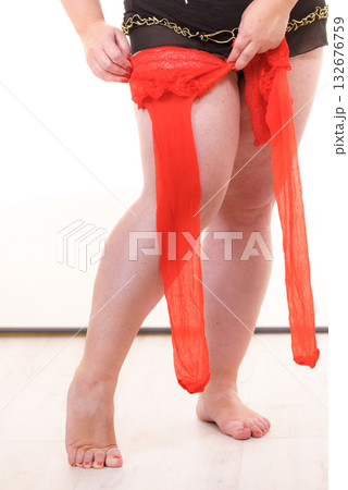 Woman plus size puts on red nylon stockings Woman plus size puts on red nylon stockings 132676759