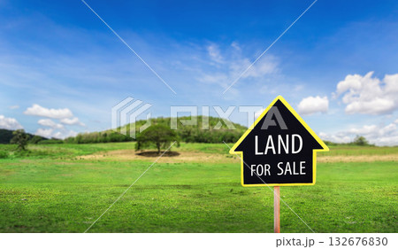 land for sale sign against trimmed lawn background. Empty dry cracked swamp reclamation soil, land plot for housing construction project in rural area and beautiful blue sky 132676830