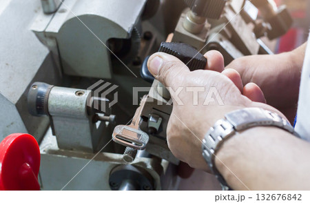 Locksmith in workshop makes new key. Professional making key in locksmith. Locksmith in workshop makes new key. Professional making key in locksmith. 132676842