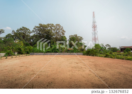 Empty dry cracked swamp reclamation soil, land plot for housing construction project with car tire print in rural area and beautiful blue sky. 132676852