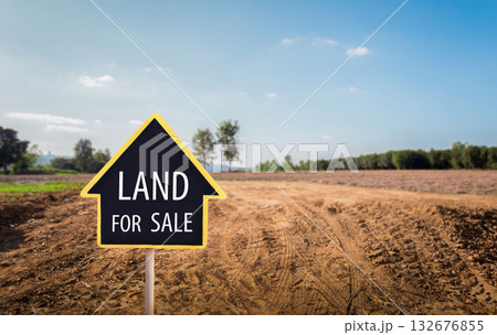 and for sale sign against trimmed lawn background. Empty dry cracked swamp reclamation soil, land plot for housing construction project in rural area and beautiful blue sky and for sale sign against trimmed lawn background. Empty dry cracked swamp reclamation soil, land plot for housing construction project in rural area and beautiful blue sky 132676855