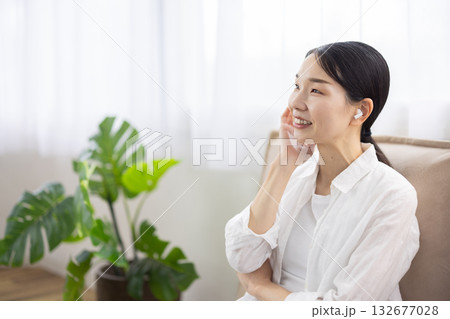 ワイヤレスイヤフォンをつけて微笑むミドル女性 ワイヤレスイヤフォンをつけて微笑むミドル女性 132677028