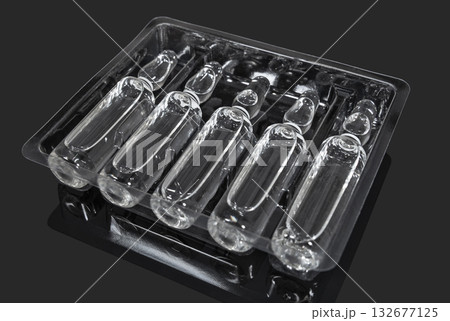 Ampoules with transparent medicine on a dark background 132677125