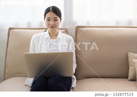 ソファに座りノートパソコンを操作するミドル女性 ソファに座りノートパソコンを操作するミドル女性 132677515