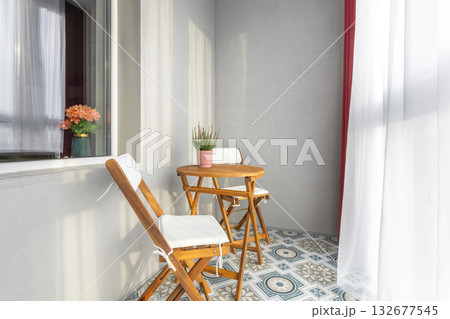 Sunny Balcony with Wooden Furniture and Patterned Floor Sunny Balcony with Wooden Furniture and Patterned Floor 132677545