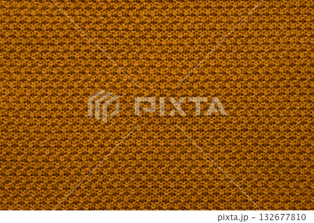 Closeup of orange knit fabric texture with warm yarns and cozy pattern background 132677810