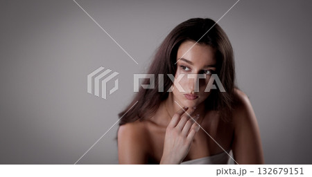 Fashion model posing with hand on her chin looking away 132679151