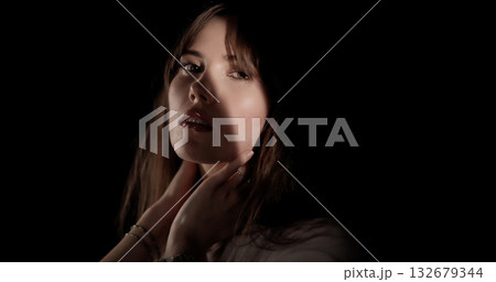 Fashion model posing in studio with hands on her neck 132679344