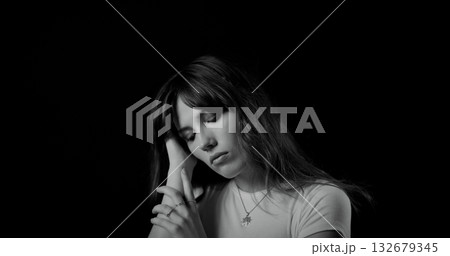 Fashion model posing with hand on her head in black and white 132679345