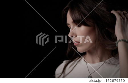 Fashion model touching her hair and looking down Fashion model touching her hair and looking down 132679350