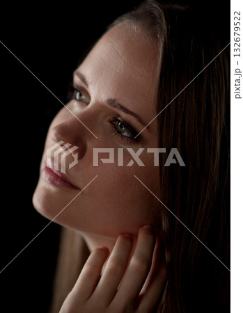 Pretty woman looking up and holding her neck with hand on black background Pretty woman looking up and holding her neck with hand on black background 132679522