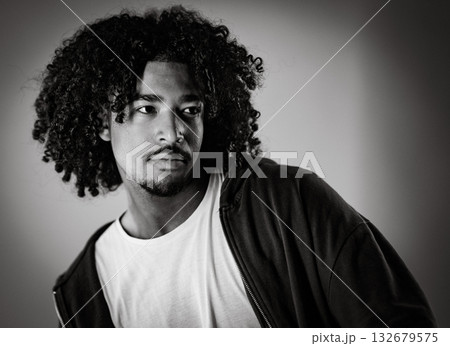Young african-american man with curly hair looking away posing in studio shot 132679575