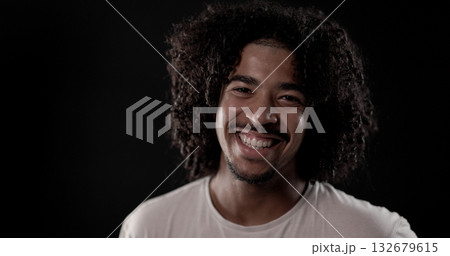 Young african-american man with curly hair smiling on black background 132679615