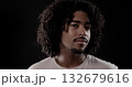 Young african-american man with curly hair posing on dark background 132679616
