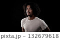 Young african-american man with curly hair looking up on black background 132679618