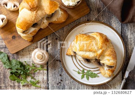 Freshly baked croissants with mushrooms and ricotta on rustic wooden table setting. Top view flat lay background. Freshly baked croissants with mushrooms and ricotta on rustic wooden table setting. Top view flat lay background. 132680627