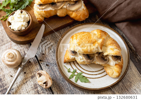Freshly baked croissants with mushrooms and ricotta on rustic wooden table setting. 132680631