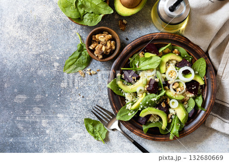 Couscous with avocado, beet, fresh spinach and dressing vinaigrette on a grey stone background. Healthy natural plant based vegetarian food, low calories dieting meal. 132680669