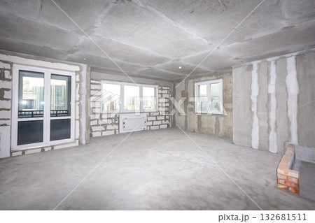 Apartment interior without finishing. Room in new building without repair, walls are not plastered. Apartment interior without finishing. Room in new building without repair, walls are not plastered. 132681511