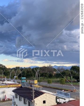 View from the roof of the house to the roofs of houses to the sea, mountains and park, thick low clouds View from the roof of the house to the roofs of houses to the sea, mountains and park, thick low clouds 132681939