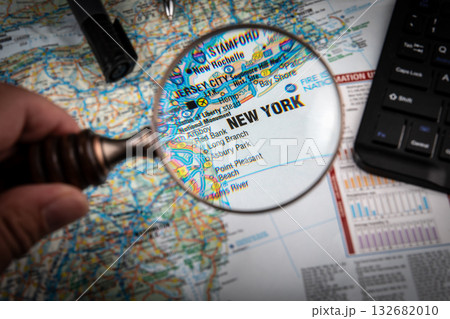 Close-Up View of New York on a Map Through Magnifying Glass with Office Desk Elements 132682010