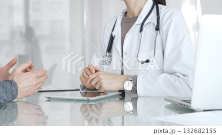 Doctor consulting patient, discussing diagnosis, using digital tablet in modern medical clinic. Medicine and health care Doctor consulting patient, discussing diagnosis, using digital tablet in modern medical clinic. Medicine and health care 132682155