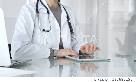 Doctor using digital tablet for remote medical consultation, providing modern healthcare services, telehealth concept. Medicine and health care Doctor using digital tablet for remote medical consultation, providing modern healthcare services, telehealth concept. Medicine and health care 132682156
