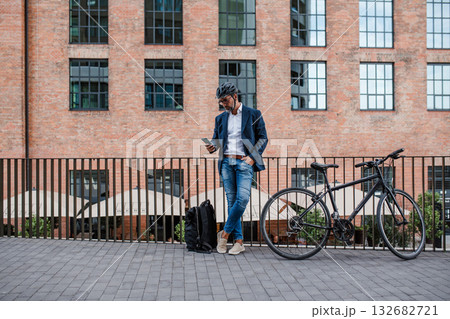City commuter riding bike from work, reading text message on phone. City commuter riding bike from work, reading text message on phone. 132682721