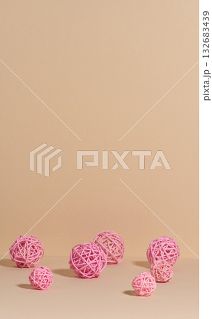 Decorative pink balls made of rattan or thread on a beige background Decorative pink balls made of rattan or thread on a beige background 132683439