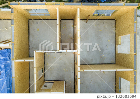 Construction of new and modern modular house. Walls made from composite wooden sip panels with styrofoam insulation inside. Building new frame of energy efficient home concept. Construction of new and modern modular house. Walls made from composite wooden sip panels with styrofoam insulation inside. Building new frame of energy efficient home concept. 132683694