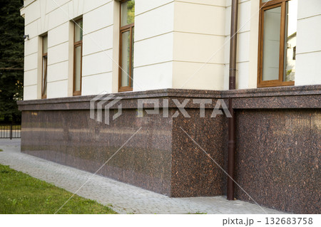 Close up view of part of a building facade with the surface of granite wall. Natural stone materials. Close up view of part of a building facade with the surface of granite wall. Natural stone materials. 132683758