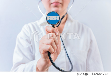 Female doctor holding stethoscope with Honduras flag. National health system of Honduras Female doctor holding stethoscope with Honduras flag. National health system of Honduras 132683778