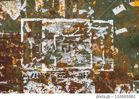 Rusty Grunge Wall with Torn Posters. Old metal surface with rust, peeling paint, ripped poster fragments forming chaotic urban texture. Concept of decay, grunge style, urban vintage background 132683862