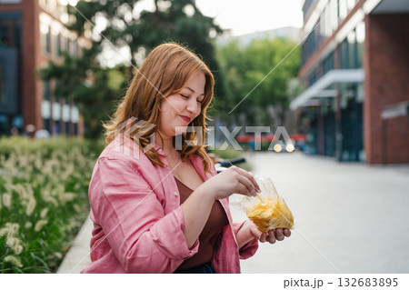 Plus size woman holding potato chip. Plus size woman holding potato chip. 132683895