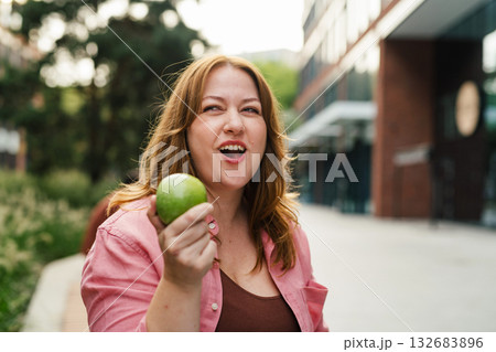 Plus size woman holding green apple. Plus size woman holding green apple. 132683896