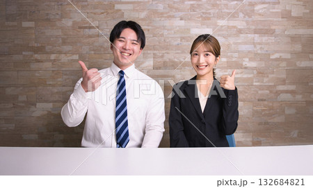 オフィスで並んで座る笑顔の若い男女 オフィスで並んで座る笑顔の若い男女 132684821