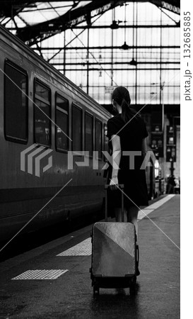 A woman with luggage on a train platform. 132685885
