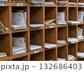 沢山の郵便物が仕訳けられている木製の棚 132686403