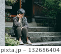 和風の建物の入り口の石段に座って物思いにふけるシニア女性 132686404