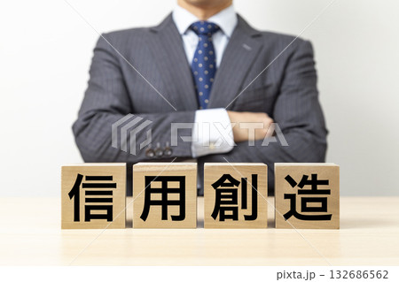「信用創造」と書かれたブロックと腕組みをするビジネスマン 「信用創造」と書かれたブロックと腕組みをするビジネスマン 132686562