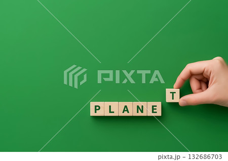 Wooden cubes spelling the word PLANET, a hand completes the word 132686703