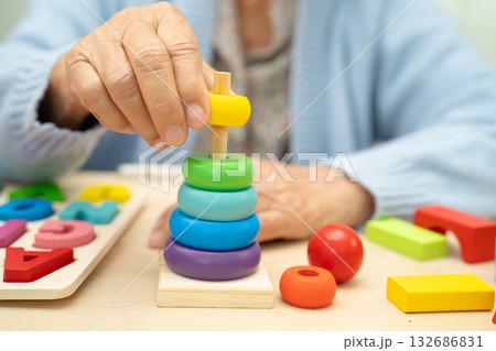 Alzheimer disease AD, Asian elderly woman patient suffering from dementia learn practical motor skills rehabilitation. 132686831