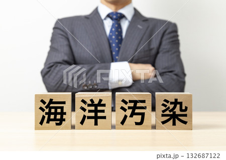 「海洋汚染」と書かれたブロックと腕組みをするビジネスマン 「海洋汚染」と書かれたブロックと腕組みをするビジネスマン 132687122