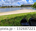 芝生と砂浜のある公園に置かれた黒い靴 132687221