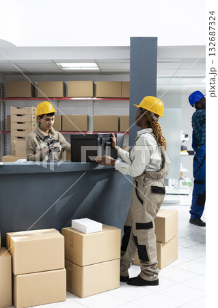 Storehouse diverse employees manage orders and scans packages for retail shipment and supply chain systems. Inventory control and bar code technology streamline the logistics process. Storehouse diverse employees manage orders and scans packages for retail shipment and supply chain systems. Inventory control and bar code technology streamline the logistics process. 132687324