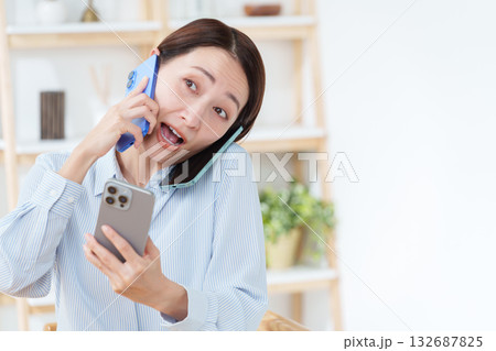スマホを複数台持つ多忙な女性 132687825