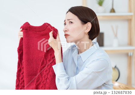 衣替えで出したセーターの臭いを嗅ぐ女性 132687830