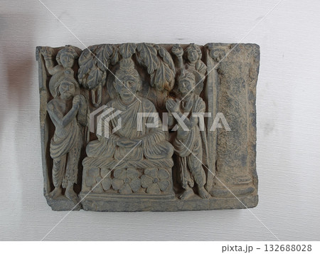 ガンダーラ美術にある仏教彫刻のひとつで人々から礼賛合掌される仏陀の姿を表したレリーフ ガンダーラ美術にある仏教彫刻のひとつで人々から礼賛合掌される仏陀の姿を表したレリーフ 132688028