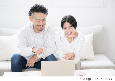 リビングでパソコンを見る夫婦 検索して見つける 引っ越しや保険などを探す リビングでパソコンを見る夫婦 検索して見つける 引っ越しや保険などを探す 132688053